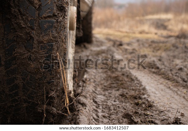 Off-road vehicle on a dirt track, off-road 4x4\
in bad weather, visible dirt on\
wheels
