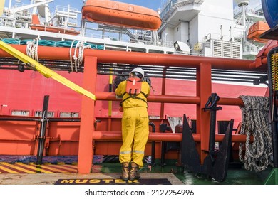 An offshore construction supervisor leaning on the railing while waiting to be transferred from a boat to a construction work barge at offshore oil field.