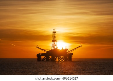 Offshore Jack Up Rig in The Middle of The Sea at Sunset Time 