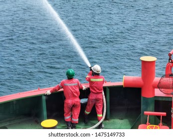 Offshore marine crew testing fire hydrant for fire drill training