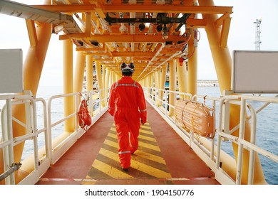 Offshore Oil And Gas Industry And Operated By Technician Petroleum. Worker Walking To Oil And Gas Plant For Work As Routine Plan. Maintenance And Operation Work Scope In Oil And Gas Plant.