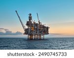 Offshore oil and gas jackup platform in the ocean during beautiful colourful sunset.