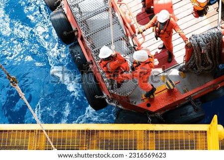 Offshore oil and gas platform during crew boat transfer worker to the platform during sunset time