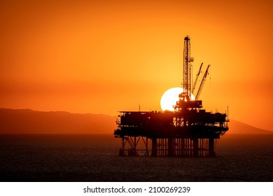 Offshore Oil Platform Off The Coast Of California Frames Against An Orange Sky Full Of Smoke From A Nearby Fire As The Sun Sets Behind The Rig.

