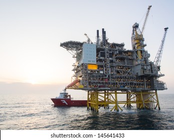 Offshore Oil Platform With A Supply Vessel On The North Sea, In The Norwegian Sector