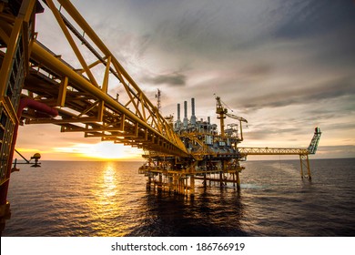 Offshore-Öl- und Bohrplattform bei Sonnenuntergang oder Sonnenaufgang. Bau von Produktionsprozessen im Meer. Energie der Welt.