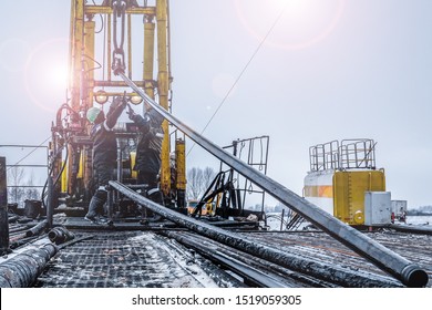 Offshore Oil Rig Worker Prepare Tool And Equipment For Perforation Oil And Gas Well At Wellhead Platform. Making Up A Drill Pipe Connection. A View For Drill Pipe Connection From Between The Stands.