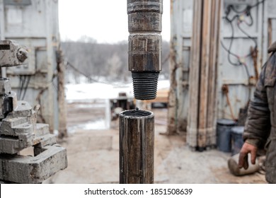 Offshore oil rig worker prepare tool and equipment for perforation oil and gas well at wellhead platform. Making up a drill pipe connection. A view for drill pipe connection from between the stands - Shutterstock ID 1851508639