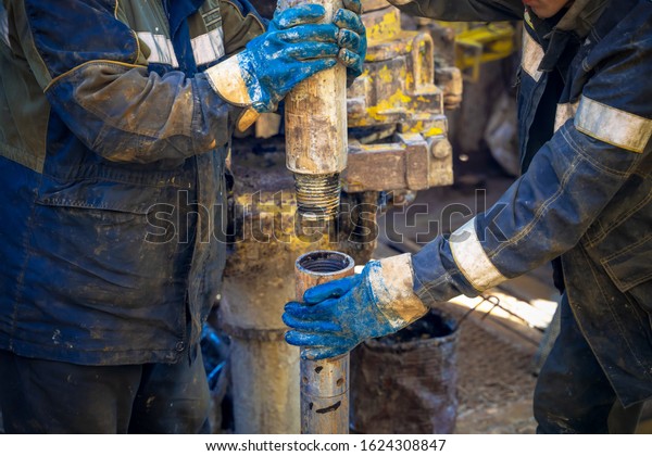 Offshore oil rig worker prepare tool and\
equipment for perforation oil and gas well at wellhead platform.\
Making up a drill pipe connection. A view for drill pipe connection\
from between the\
stands.