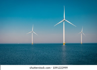 Offshore and Onshore Windmill farm in the ocean ,windmills isolated at sea on a beautiful bright day Netherlands Flevoland Noordoostpolder  - Shutterstock ID 1091222999