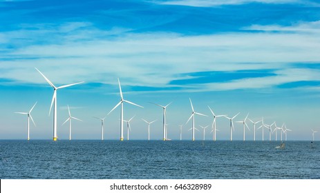 Offshore and onshore windmill park ,Windmill farm green energy at sea,Windmill turbines by the ocean