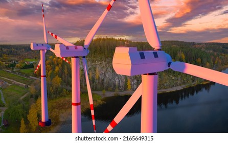 Offshore Power Plant. Windmills Rise Above Lake. Giant Wind Turbines. Concept Of Global Energy Consumption. Green Energy. Windmill Blades. Three Wind Turbines Before Sunset. Electricity From Breeze
