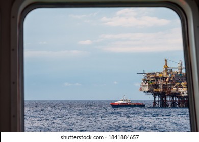 Offshore Production Platform Viewed From An Anchor Handling Tug Boat Bridge With A Fast Crew Boat Approaching For Crew Change