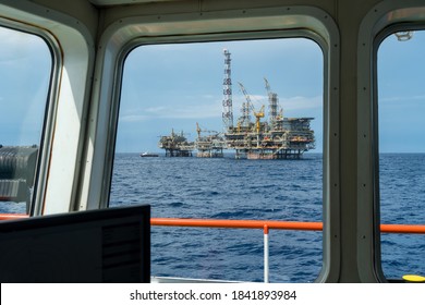 Offshore Production Platform Viewed From An Anchor Handling Tug Boat Bridge With A Fast Crew Boat Approaching For Crew Change