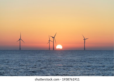 Offshore Scroby Sands Wind Farm, located in the North Sea off the East Coast of England with the sun just starting to appear above the horizon.