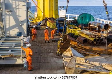 Offshore Terengganu, Malaysia, August 2015. Offshore workers performing anchor handling activities by lifting of an anchor on a construction barge at ExxonMobil oilfield, Terengganu, Malaysia