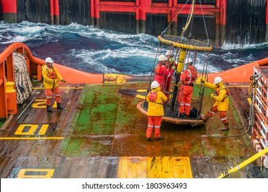 Offshore Terengganu, Malaysia - May 20, 2017: A group of offshore crews being transferred from a tug boat to a work barge using personal basket transfer for pipeline installation 