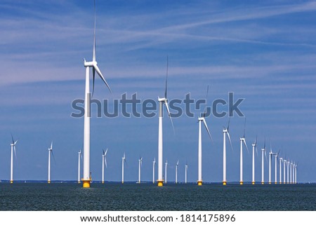 Offshore wind farm with two rows of wind turbines or wind wheels at the IJsselmeer in the Netherlands, Noordoostpolder, Flevoland. Energy transition.