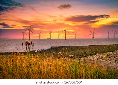 Offshore Wind Turbine in a Wind farm under construction off the England coast at sunset