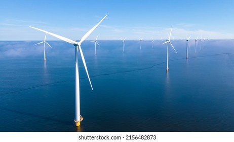 Offshore Windmill farm in the ocean Westermeerwind park, windmills isolated at sea on a beautiful bright day Netherlands Flevoland Noordoostpolder. Huge windmill turbines - Shutterstock ID 2156482873