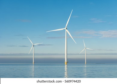 Offshore Windmill farm in the ocean  Westermeerwind park 3 windmills isolated at sea on a beautiful bright day Netherlands Flevoland Noordoostpolder January 2017