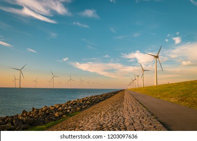 Offshore Windmill Farm In The Ocean   , Windmills Isolated At Sea On A Beautiful Bright Day, Wind Mills During Sunset In The Netherlands