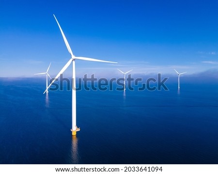 offshore windmill park with clouds and a blue sky, windmill park in the ocean drone aerial view with wind turbine Flevoland Netherlands Ijsselmeer
