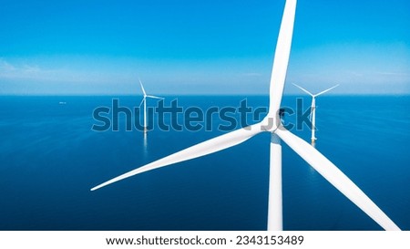 offshore windmill park with clouds and a blue sky, windmill park in the ocean aerial view with wind turbine Flevoland Netherlands Ijsselmeer. Green Energy in the Netherlands on a sunny day