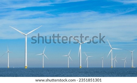 offshore windmill park with clouds and a blue sky, windmill park in the ocean aerial view with wind turbine Flevoland Netherlands Ijsselmeer. Green energy 