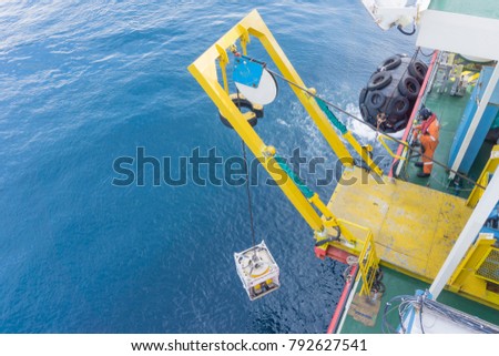 Offshore worker standing on Remote Operated Vehicle (ROV) platform deploy ROV to the open sea.