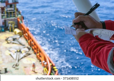 Offshore Worker Taking Note While Performing Anchor Handling Operation At Terengganu Oilfield, Malaysia