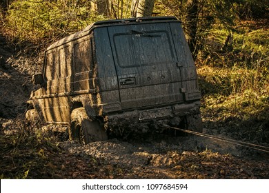 Ofroad For Hard Man. Off Road Car Going Through Mud In Forest. SUV Stuck On Country Road With Nature On Background. Dirty Offroad Car Needs Help. Adventure, Extreme Driving And Challenge Concept