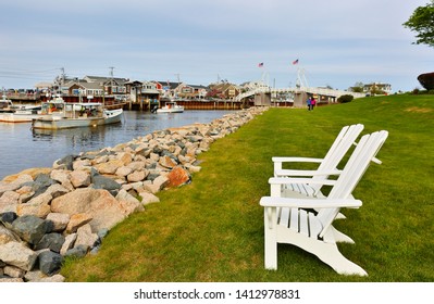 Ogunquit, Maine - May 25, 2019: Two white wooden chairs facing the Perkins Cove, Ogunquit Maine. on a sunny early morning.