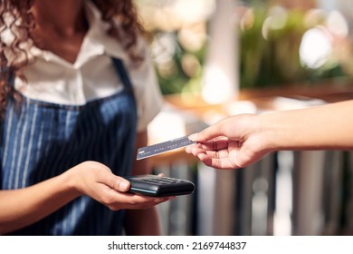 Oh, definitely tap. Shot of a customer using a card and an NFC scanner to make a card payment.