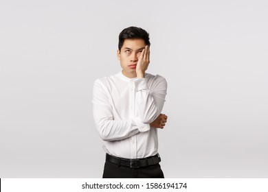 Oh god please make it stop. Annoyed, bothered and distressed young asian man waiting for something over, roll eyes and facepalm irritated, standing displeased, dont like party, think its boring - Shutterstock ID 1586194174