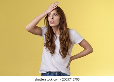Oh gosh how stupid. Shocked embarrassed ambushed curly-haired girl popping eyes punch forehead make facepalm gasping stare aside bothered forgot cancel appointment stand yellow background