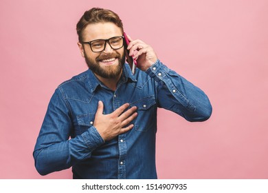 Oh, Great News! Smiling Young Casual Man Talking On The Phone Isolated Against Pink Background.