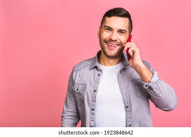 Oh, Great News! Smiling Young Casual Man Talking On The Mobile Phone On The Pink Background. Isolated. Using Phone.