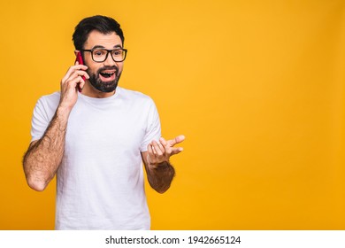 Oh, Great News! Smiling Young Casual Bearded Man Talking On The Phone Isolated Over Yellow Background.