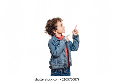 oh look, Portrait of an astonished child pointing to an empty place on white background, expressing his surprise and showing the space for advertising.
