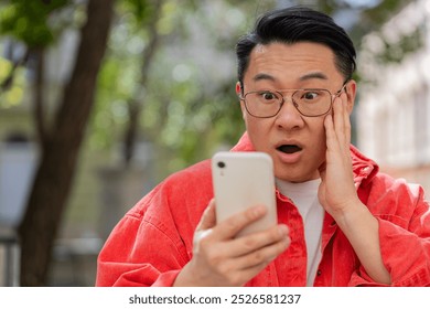 Oh my God Wow. Excited happy joyful winner Asian middle-aged man use smartphone celebrating win good message news lottery casino jackpot victory outdoors. Chinese guy on urban city street. Horizontal - Powered by Shutterstock