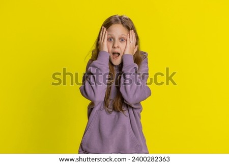 Oh my God, Wow. Young preteen child girl kid looking surprised at camera with big eyes shocked by sudden victory game winning lottery goal achievement good news. Happy children on yellow background