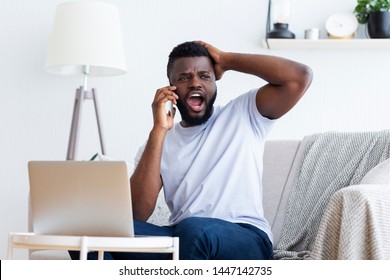 Oh No! Disappointed Young African-american Man Using Laptop And Talking On Phone With Hand On Head, Copy Space