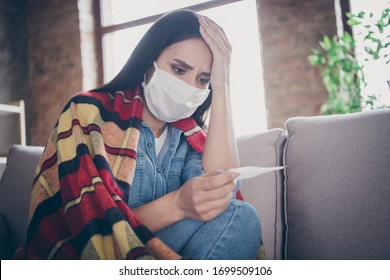 Oh no i have corona virus. Frustrated panic shocked girl feel ache measure temperature covid-19 sars-cov-2 symptom touch hand head sit couch plaid blanket cover jeans shirt in house indoors - Powered by Shutterstock