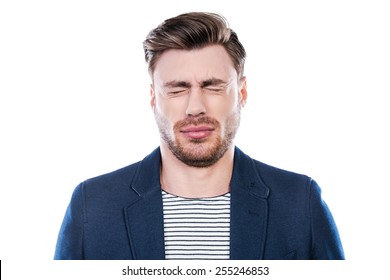 Oh No! Portrait Of Young Man Expressing Negativity And Keeping Eyes Closed While Standing Against White Background