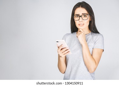 Oh No! Really? Shocked Young Woman Looking At Mobile Phone Reading News, Wearing Casual, Isolated On White Background.