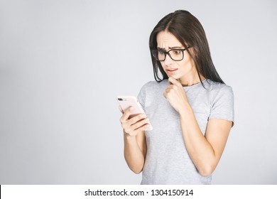 Oh No! Really? Shocked Young Woman Looking At Mobile Phone Reading News, Wearing Casual, Isolated On White Background.