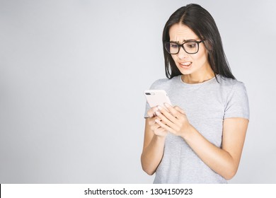 Oh No! Really? Shocked Young Woman Looking At Mobile Phone Reading News, Wearing Casual, Isolated On White Background.