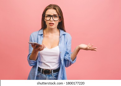 Oh No! Really? Shocked Young Woman Using Mobile Phone, Wearing Casual, Isolated On Pink Background.