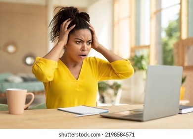 Oh No, Shocking Business News Concept. Emotional African American Businesswoman Looking At Laptop In Shock And Touching Head, Having Problem, Sitting At Desk At Home